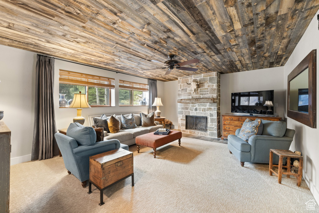 Carpeted living area with wood ceiling, a fireplace, and a ceiling fan