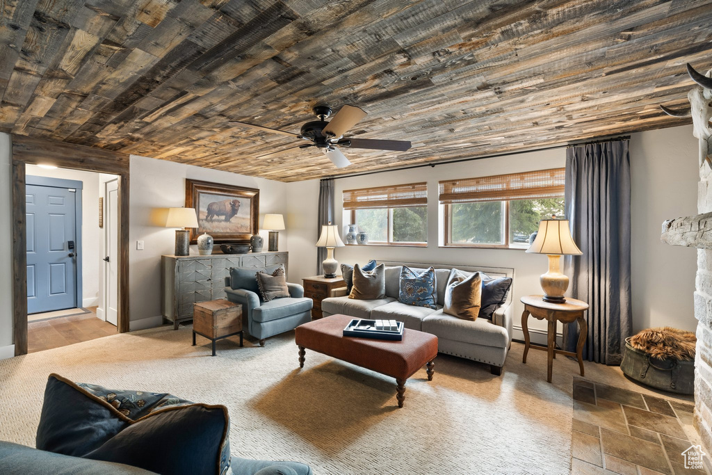 Living area featuring wooden ceiling, a ceiling fan, and a baseboard heating unit