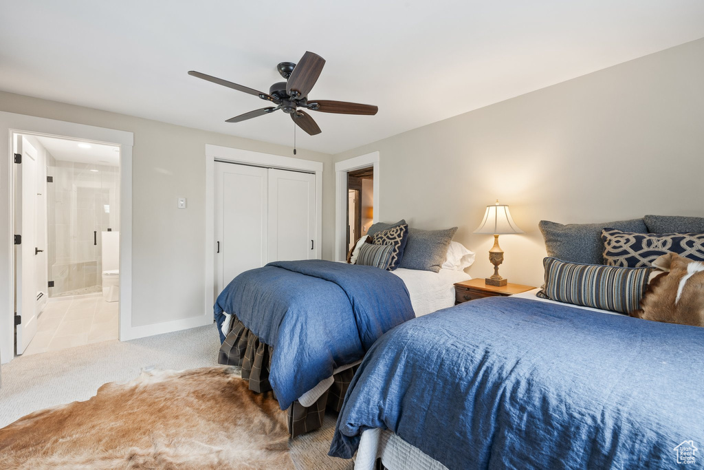 Carpeted bedroom with a closet, a ceiling fan, and connected bathroom