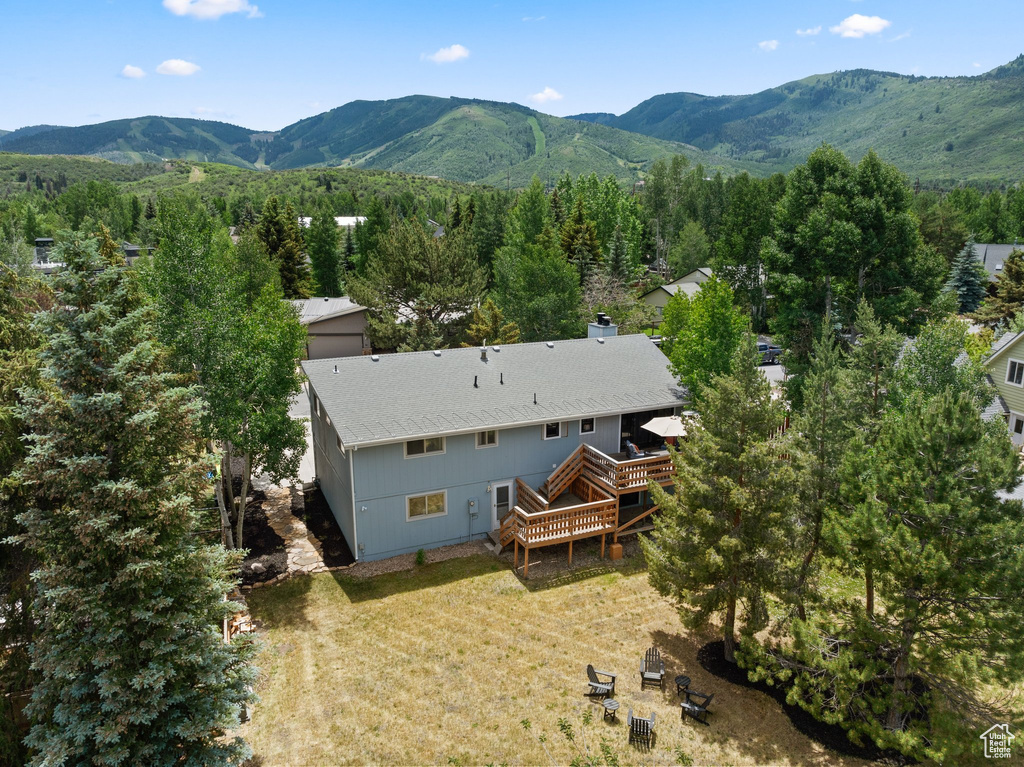 Aerial view of property and surrounding area with a mountain backdrop