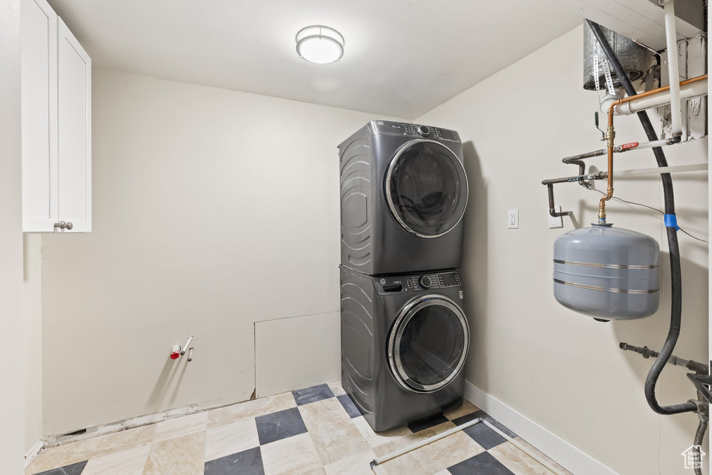 Laundry room featuring estacked washer and dryer and baseboards