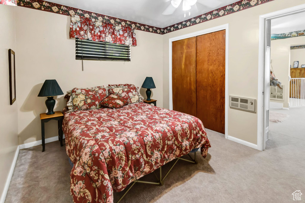Carpeted bedroom featuring a closet and ceiling fan