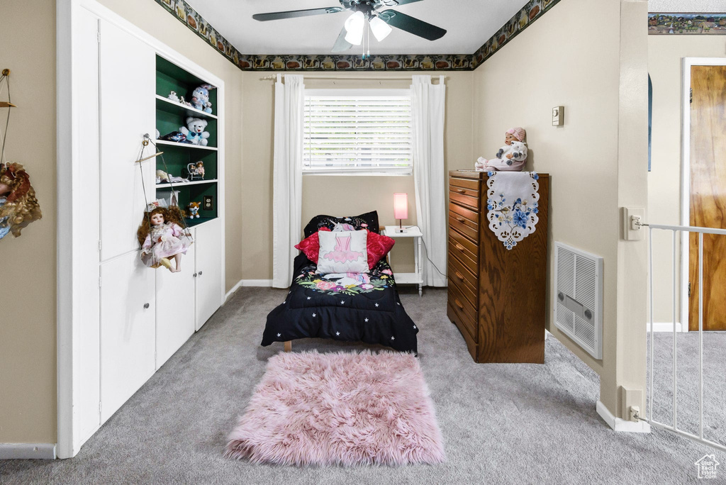 Sitting room featuring heating unit, carpet, and a ceiling fan