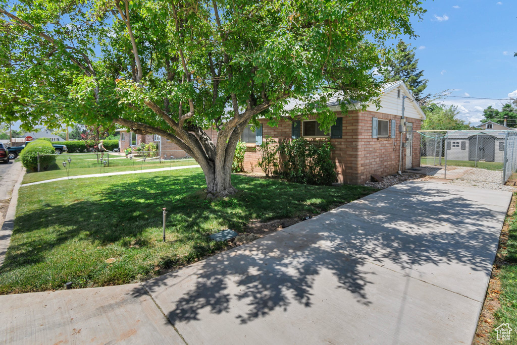 View of front facade with driveway, brick siding, and a gate