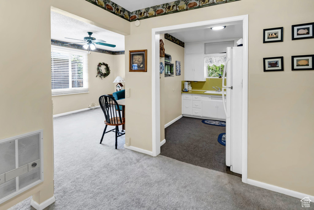 Corridor featuring dark carpet and baseboards