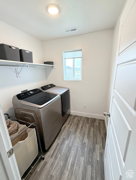 Washroom featuring washing machine and dryer and wood finished floors