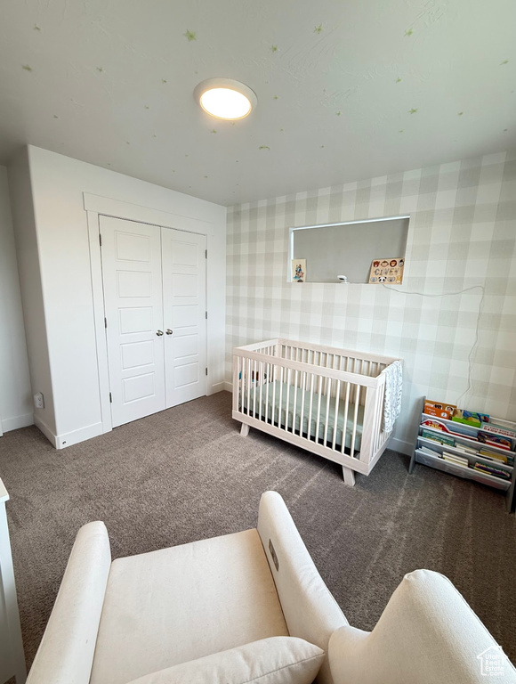 Bedroom featuring carpet flooring, wallpapered walls, and a closet