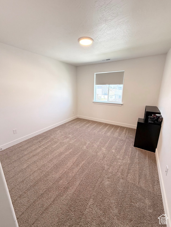 Unfurnished room featuring carpet and baseboards