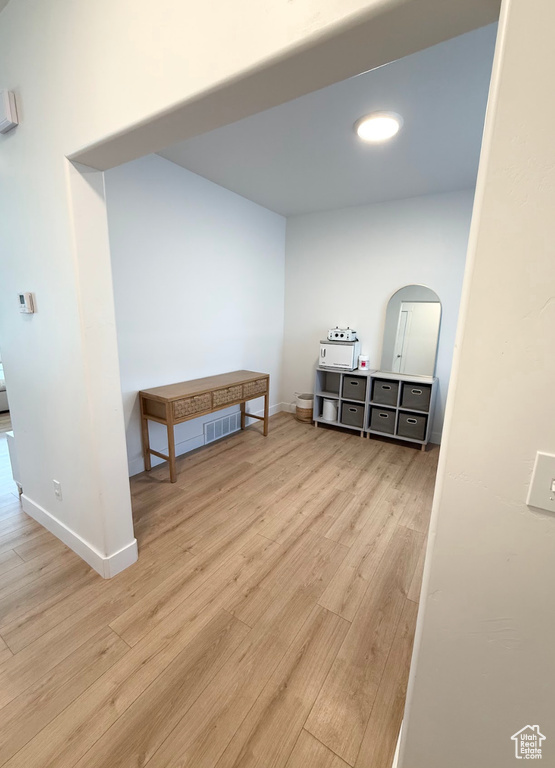 Hallway featuring wood finished floors and arched walkways
