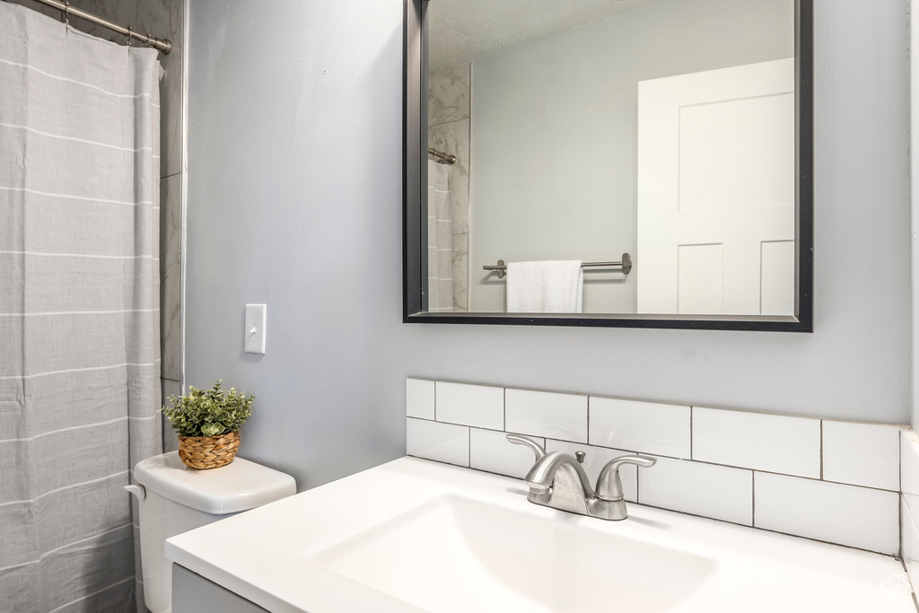 Full bathroom featuring decorative backsplash, vanity, and a shower with shower curtain