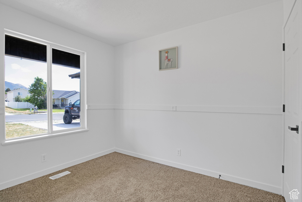 Unfurnished room featuring carpet and baseboards