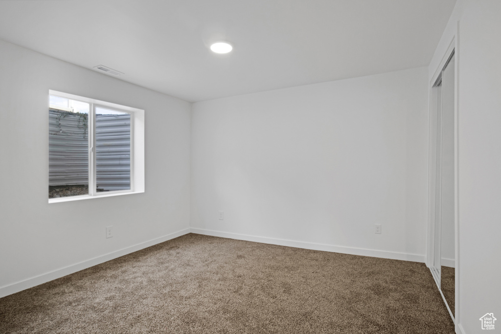 Empty room with carpet flooring and baseboards