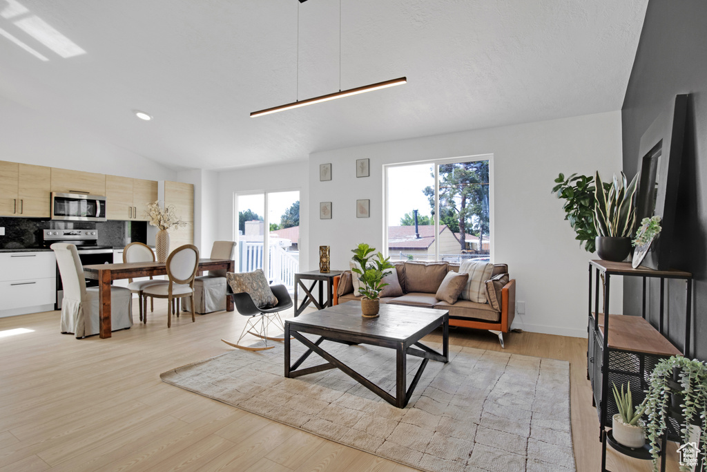Living area with light wood-style flooring and lofted ceiling