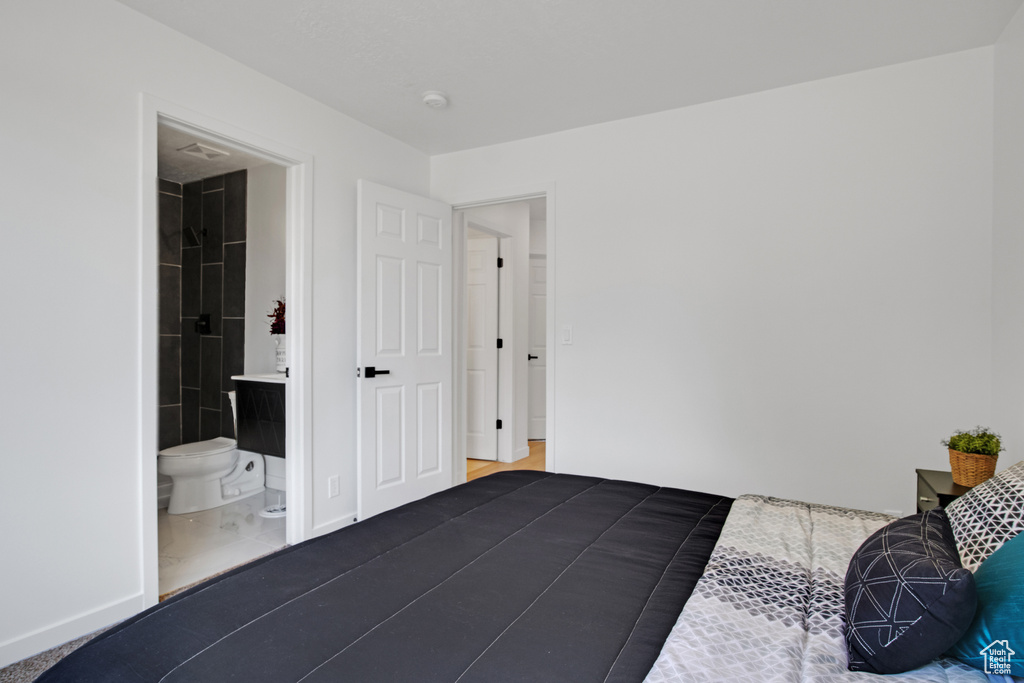 Bedroom with baseboards and ensuite bathroom