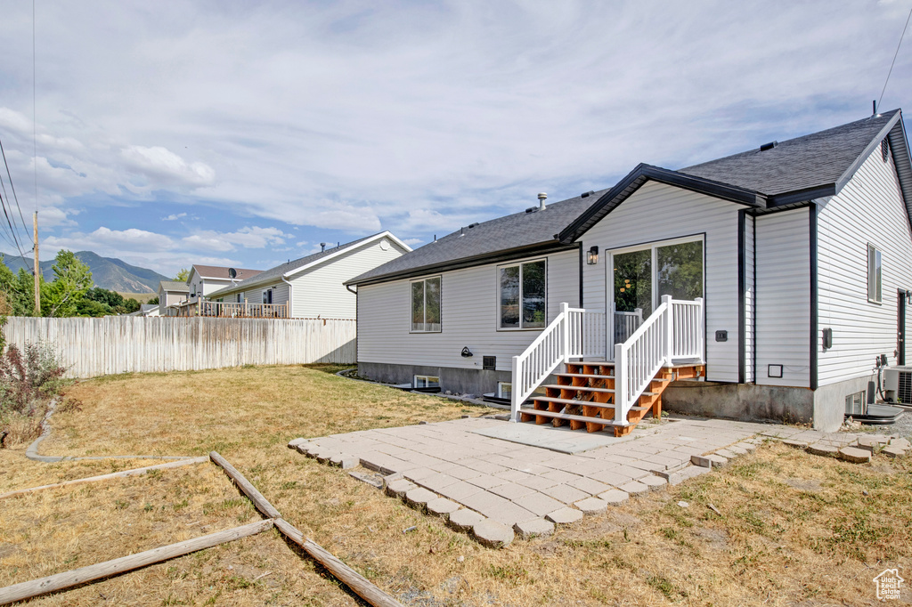 Back of house featuring a mountain view and a patio area
