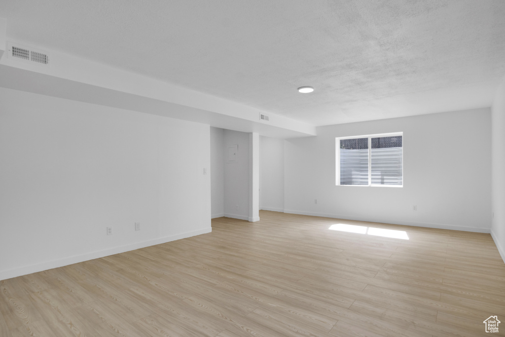 Unfurnished room with light wood-style floors and baseboards