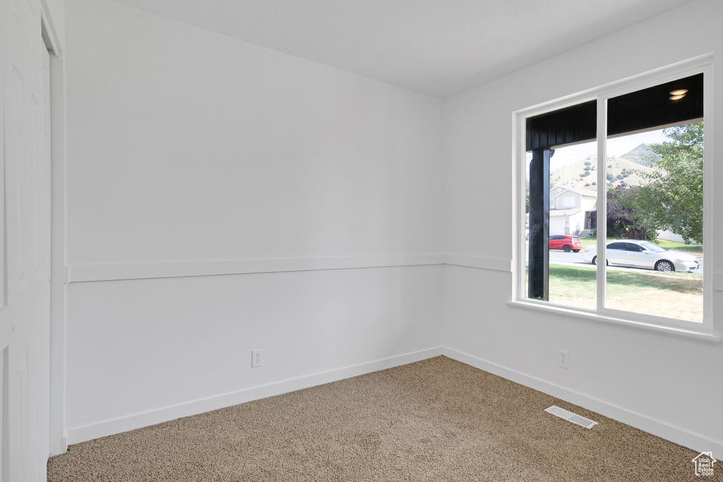 Carpeted spare room with baseboards