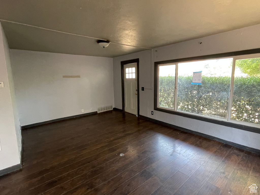 Foyer with dark wood finished floors and baseboards