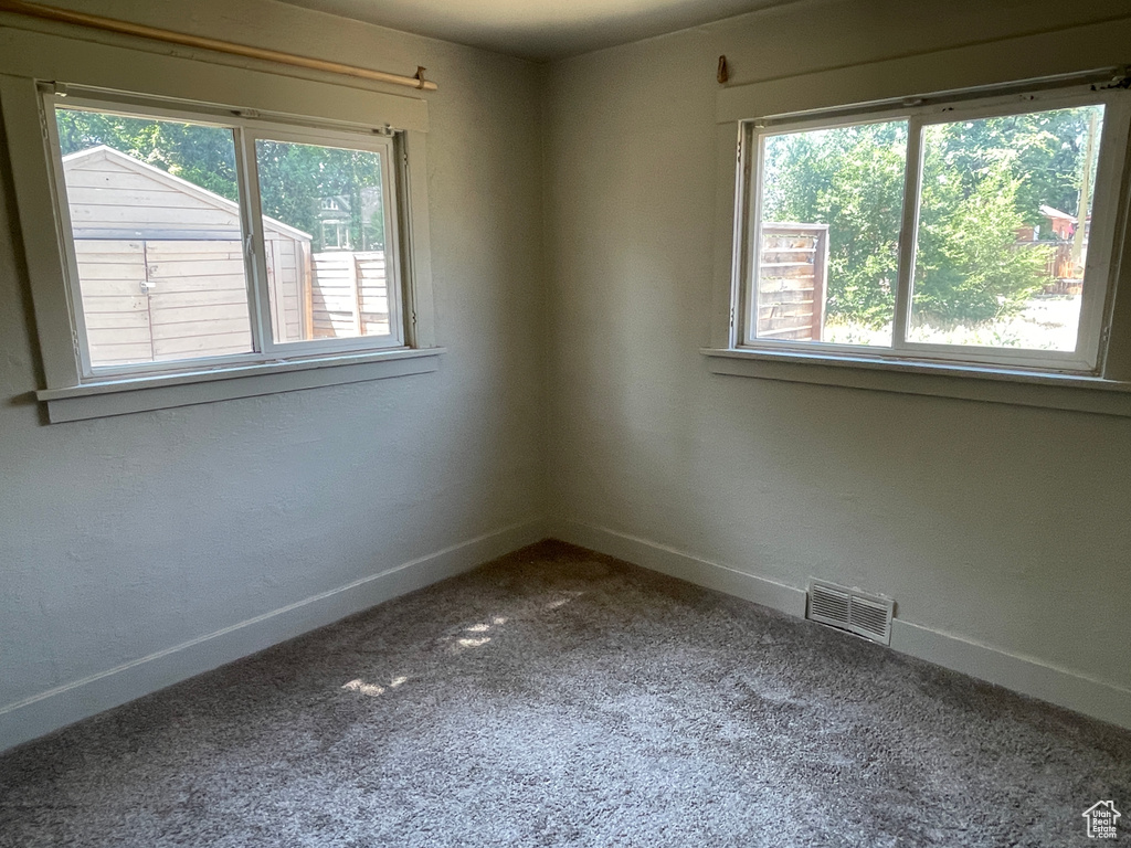 Carpeted spare room featuring baseboards