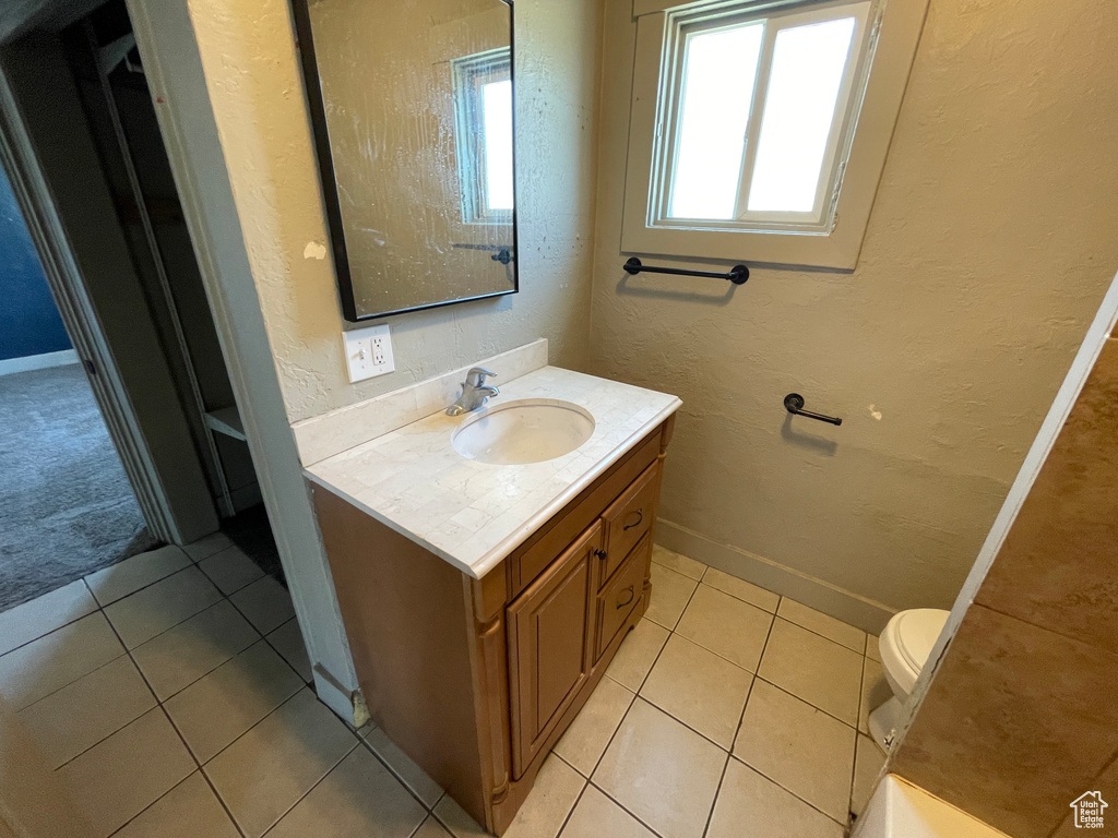 Bathroom with vanity, tile patterned floors, and a textured wall