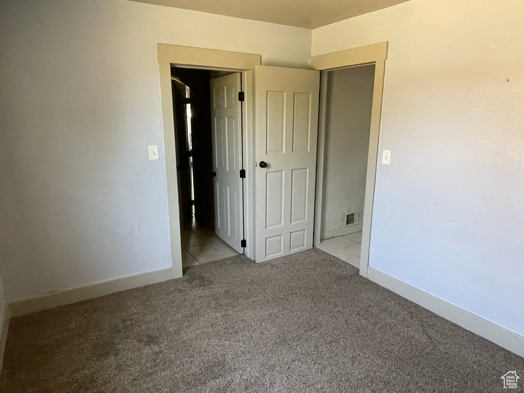 Unfurnished bedroom featuring carpet floors and baseboards