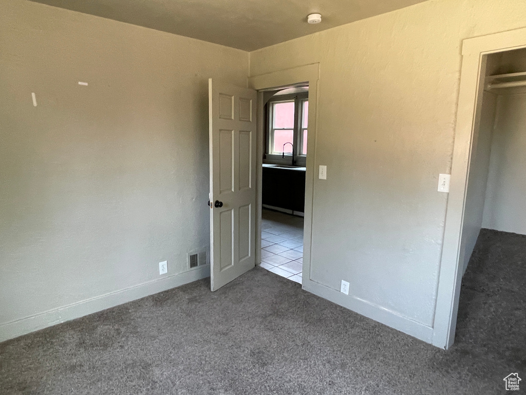 Unfurnished bedroom featuring carpet and a sink