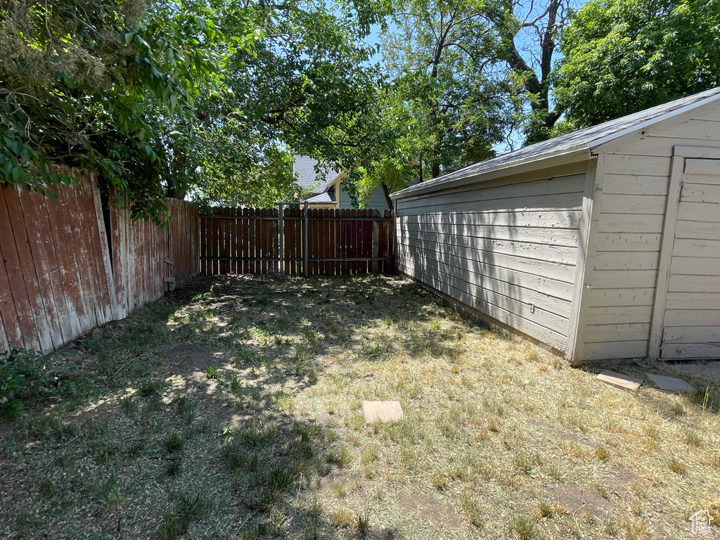 Fenced yard featuring an outdoor structure