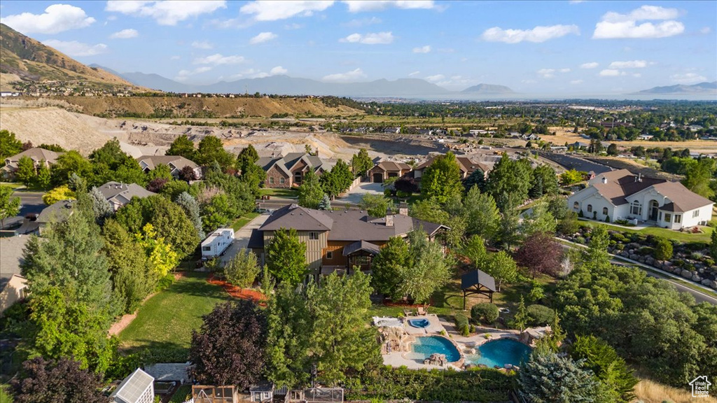 Aerial view of residential area with a mountain backdrop and a pool