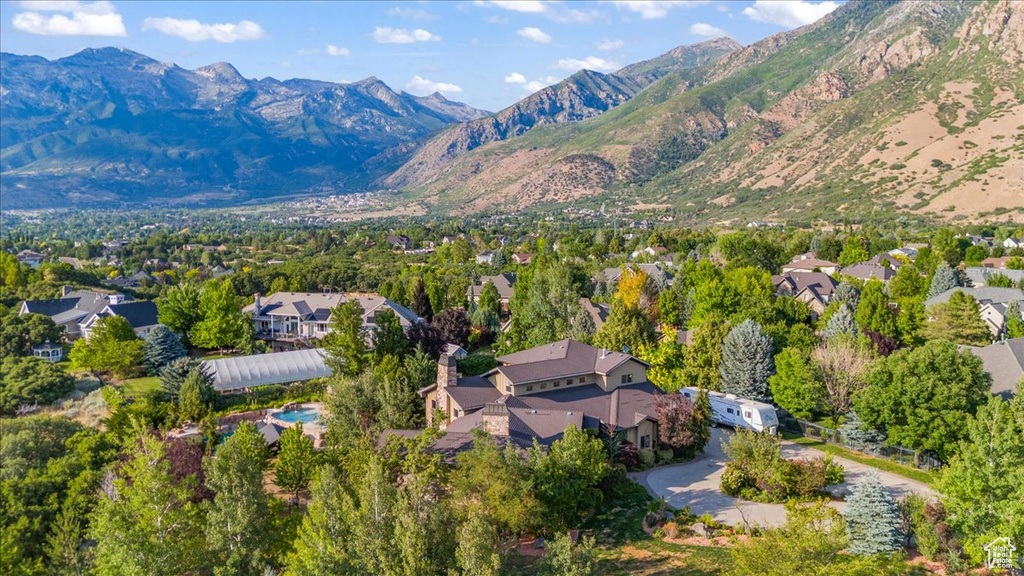 Aerial view of property and surrounding area with mountains and nearby suburban area