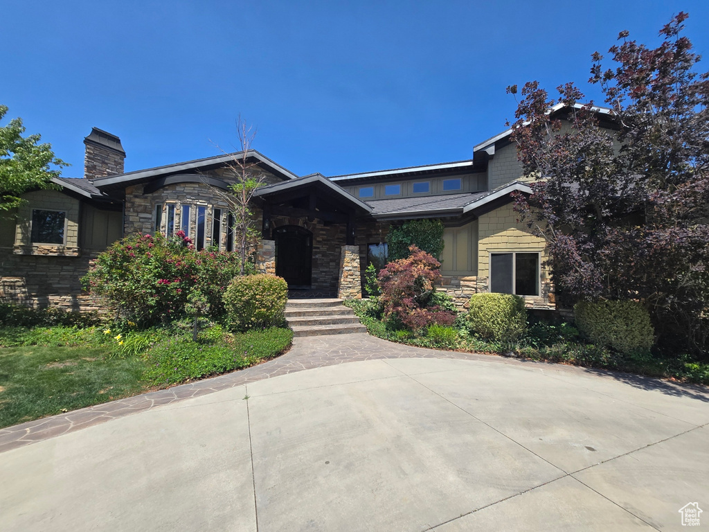 Craftsman house with stone siding and a chimney