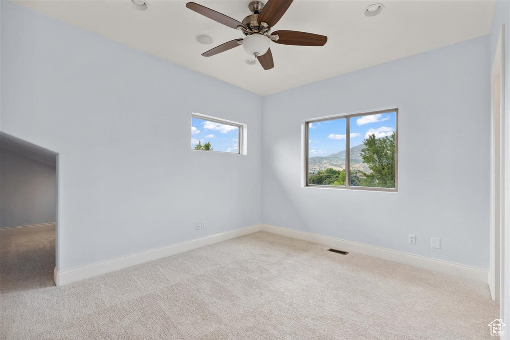 Carpeted empty room with ceiling fan and recessed lighting