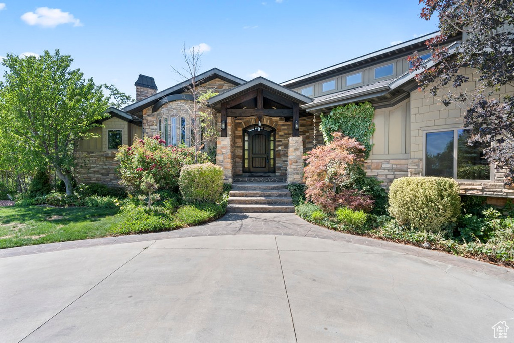 Craftsman-style home with stone siding and a chimney