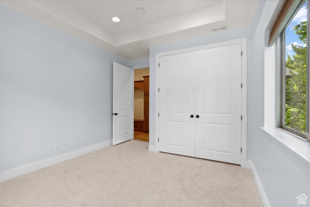 Unfurnished bedroom featuring light carpet, a closet, and recessed lighting