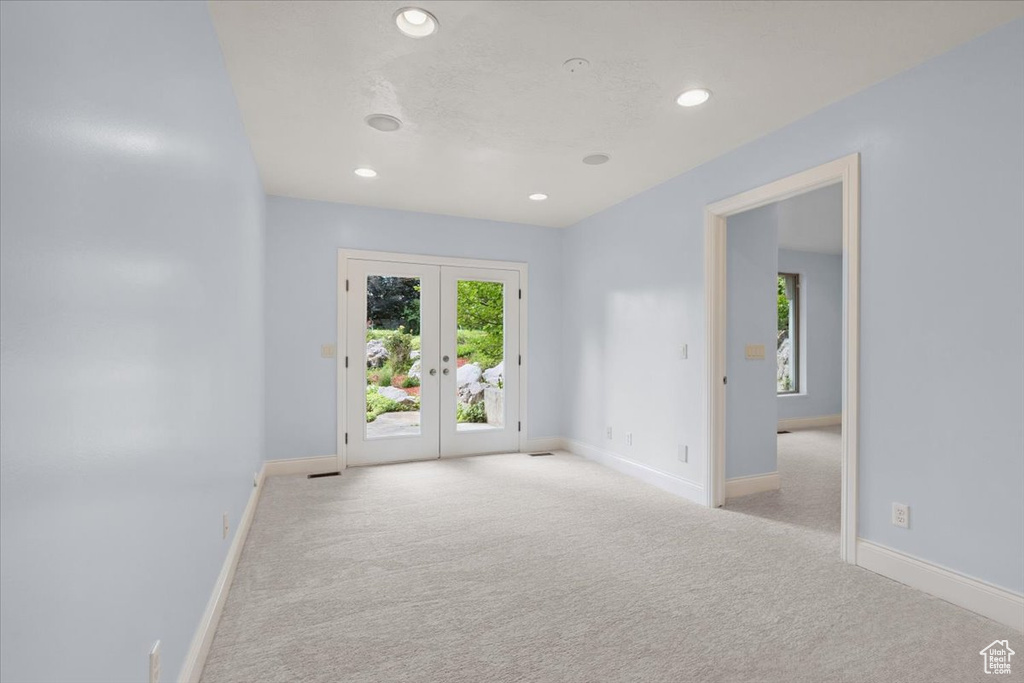 Unfurnished room featuring carpet, french doors, recessed lighting, and healthy amount of natural light