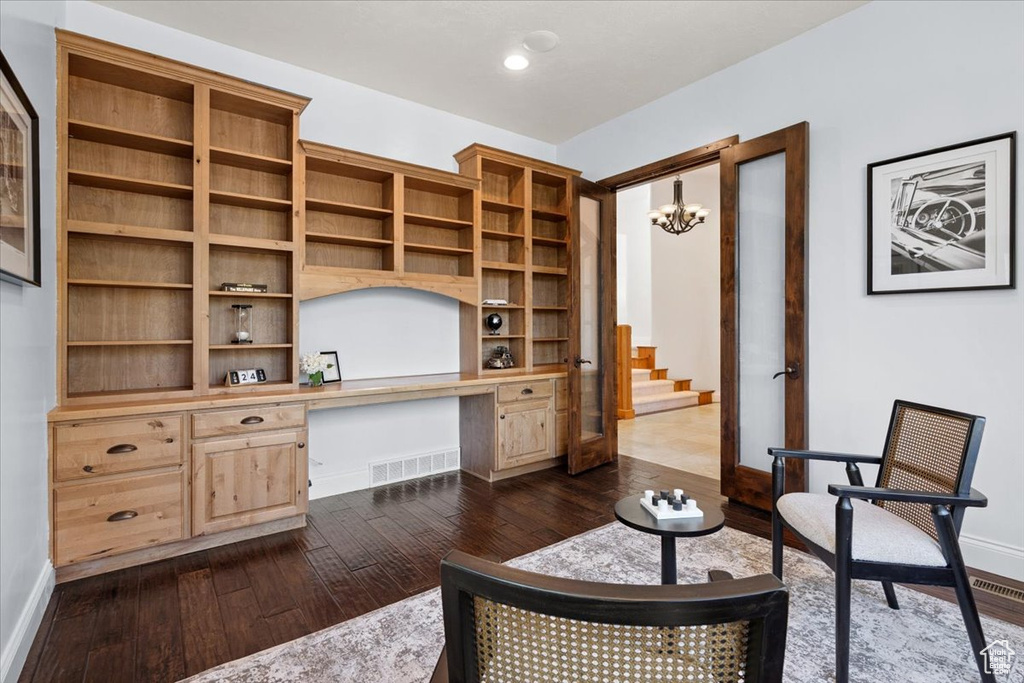 Living area with built in study area, dark wood-style flooring, a chandelier, stairs, and recessed lighting