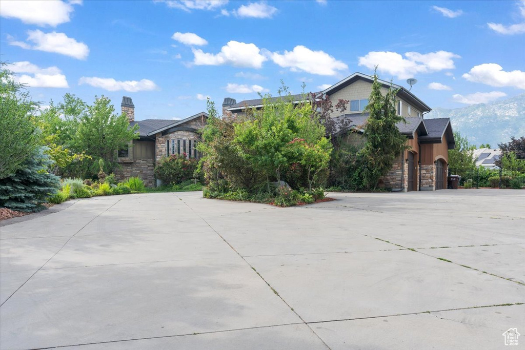 View of front of property featuring stone siding and curved driveway