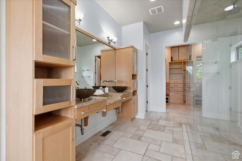Bathroom featuring vanity, a shower with door, and stone tile floors