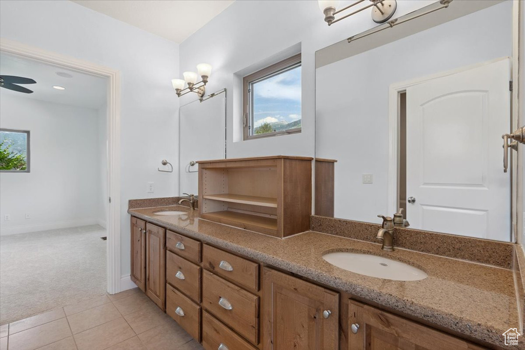 Full bathroom with double vanity, tile patterned flooring, and a ceiling fan