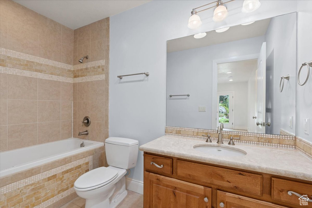 Full bathroom featuring vanity, tiled shower / bath combo, and tile patterned floors