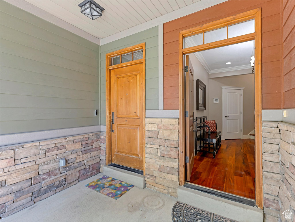Entrance to property featuring covered porch and stone siding