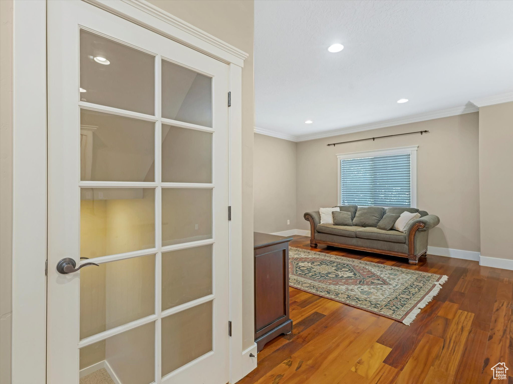 Living area featuring crown molding, wood finished floors, and recessed lighting