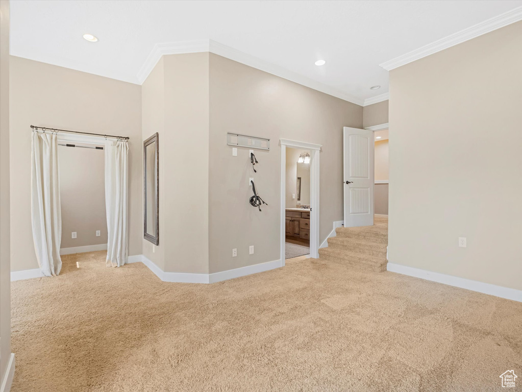 Spare room featuring light carpet, crown molding, and recessed lighting