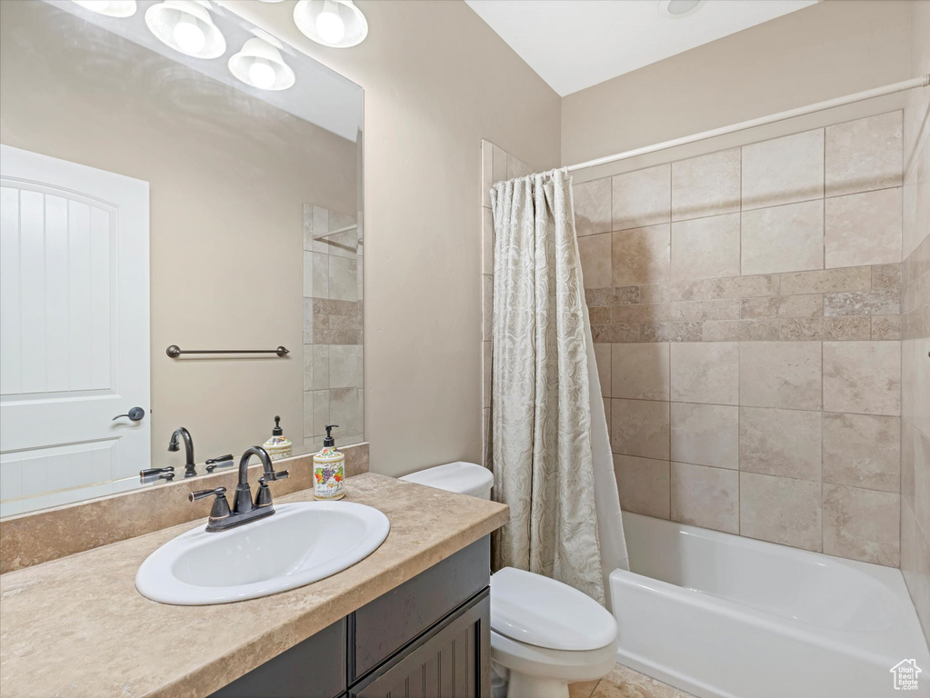 Bathroom featuring vanity and shower / bath combo with shower curtain