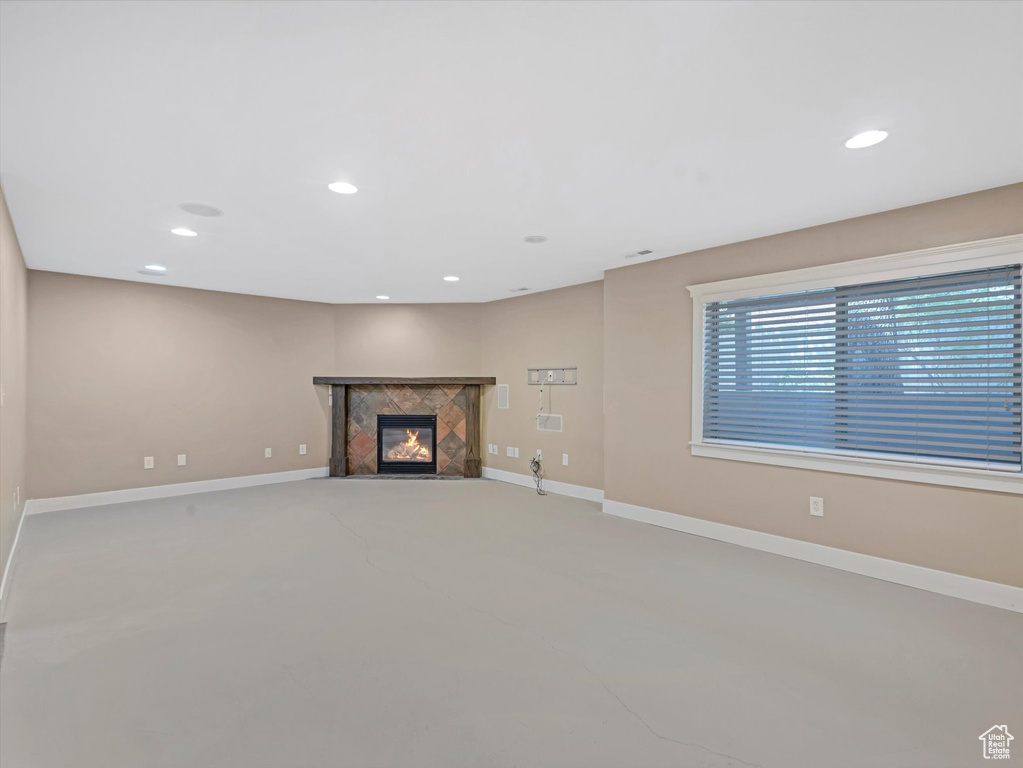 Unfurnished living room with a high end fireplace, recessed lighting, and concrete floors