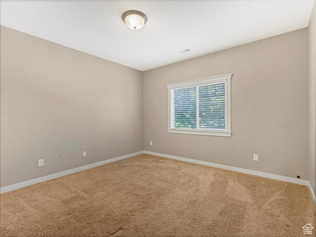 Unfurnished room featuring carpet and baseboards