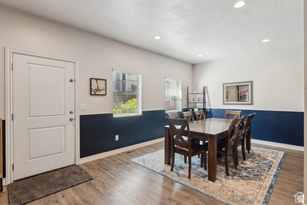 Dining room featuring a textured ceiling, wood finished floors, and recessed lighting