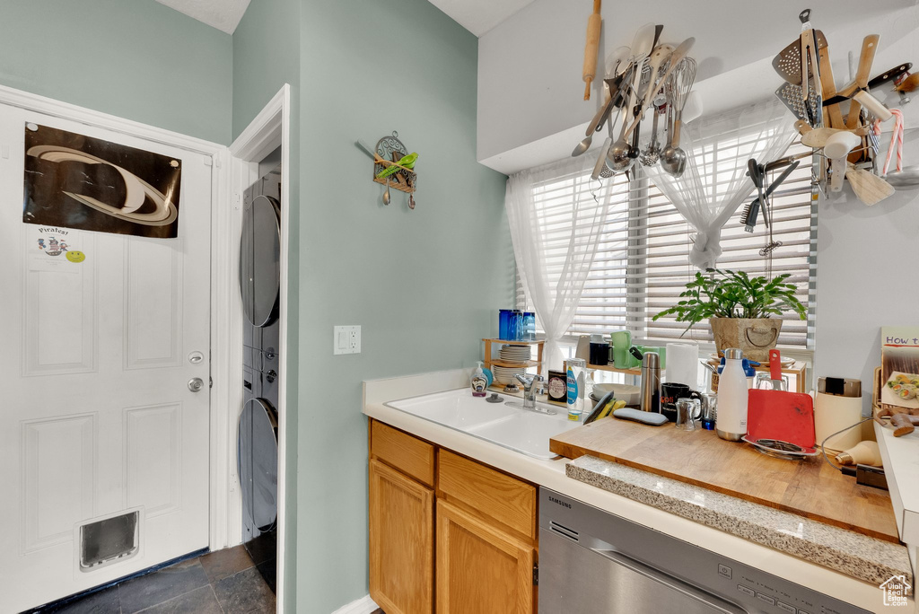 Kitchen with stacked washer / dryer, dishwasher, and light countertops