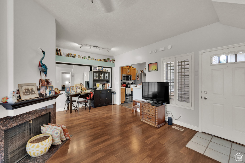 Living area with wood finished floors, a premium fireplace, and ceiling fan