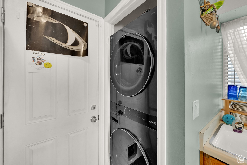 Washroom featuring estacked washer and dryer and a sink