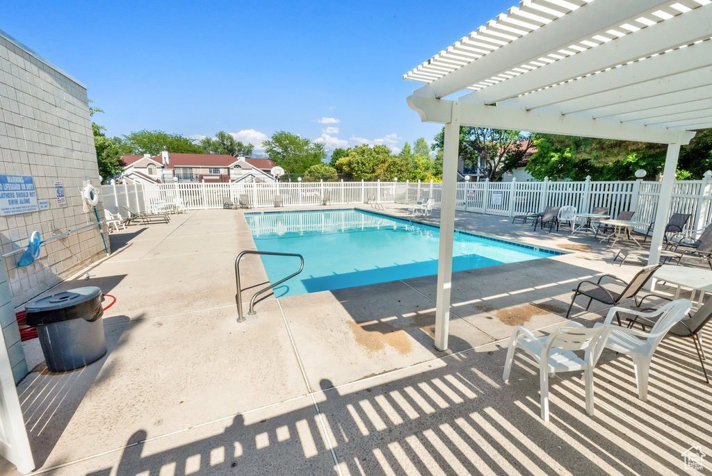 Community pool with a pergola and a patio area